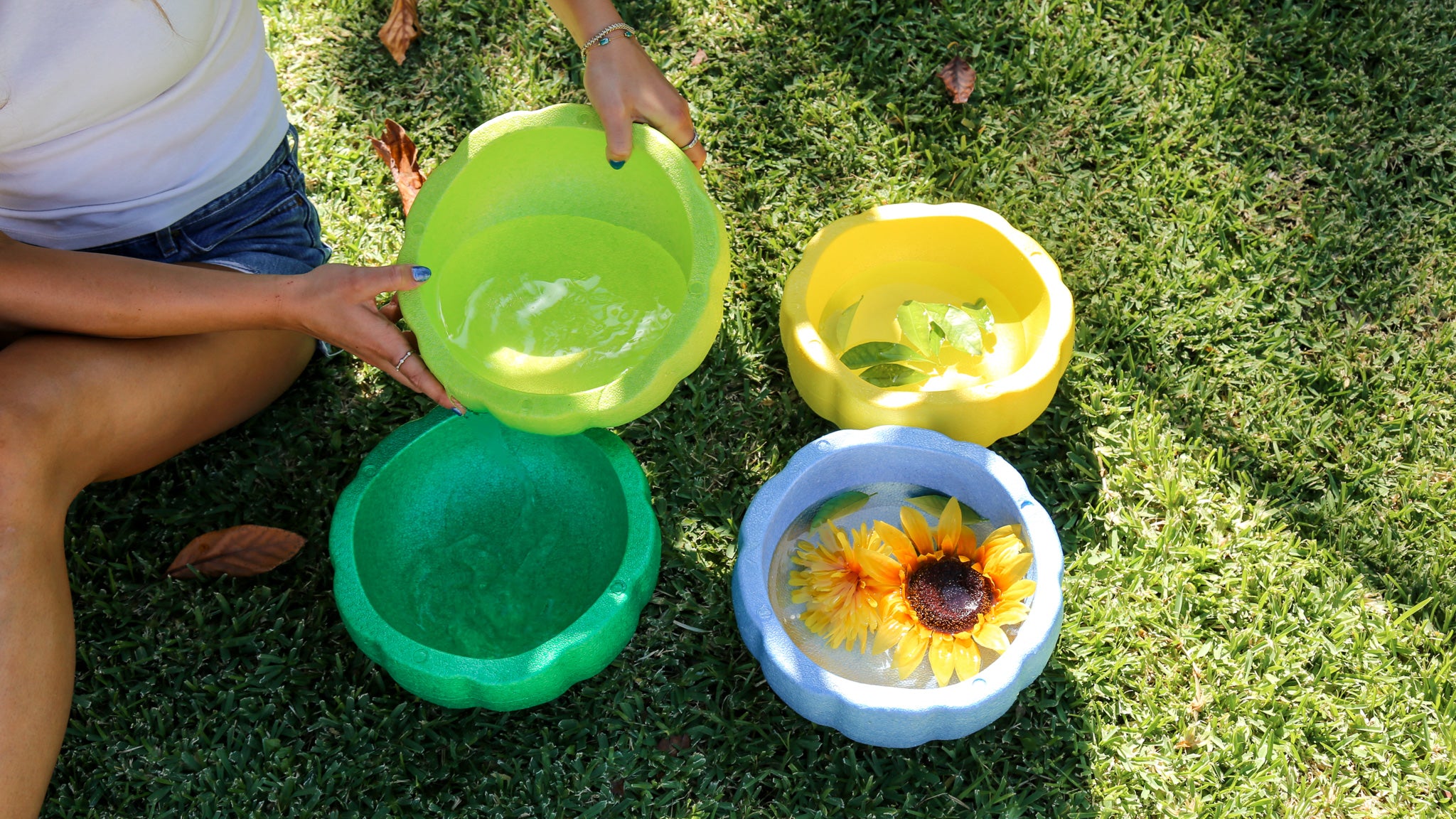 4 colorful foam stacking stones filled with water and flower by an adult for kids education